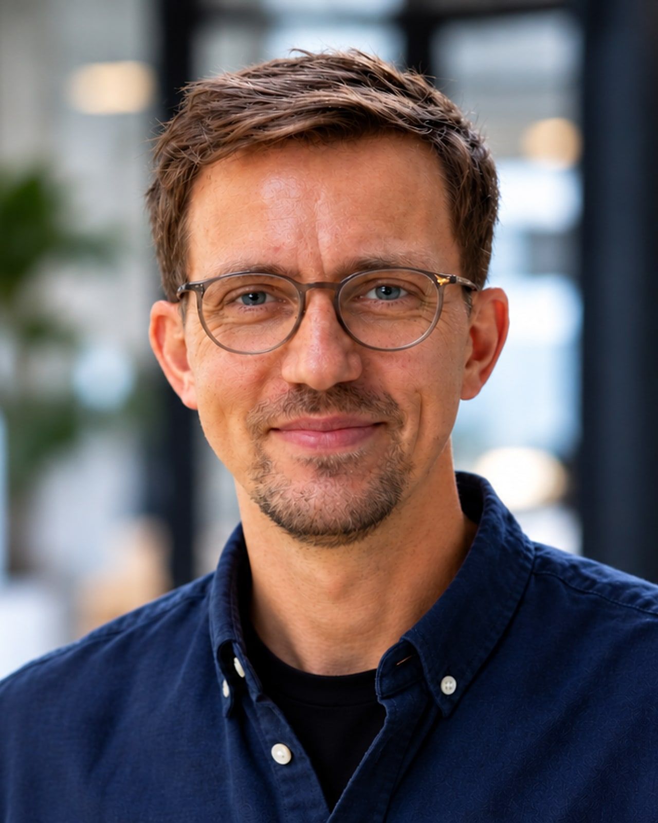 Steve Killian mit Brille und dunkelblauem Hemd, im Hintergrund ein helles Büro